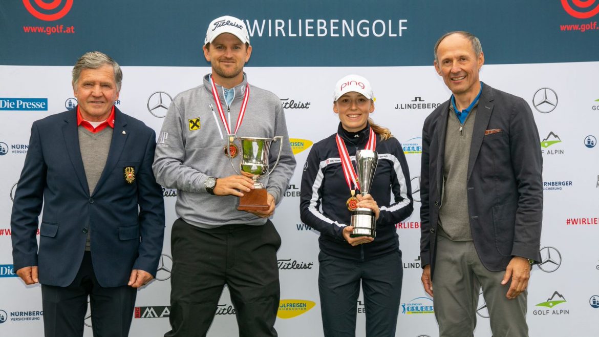 Zwei Männer und zwei Frauen stehen, zwei halten Golftrophäen und Medaillen, bei einer Golfveranstaltung im Hintergrund.