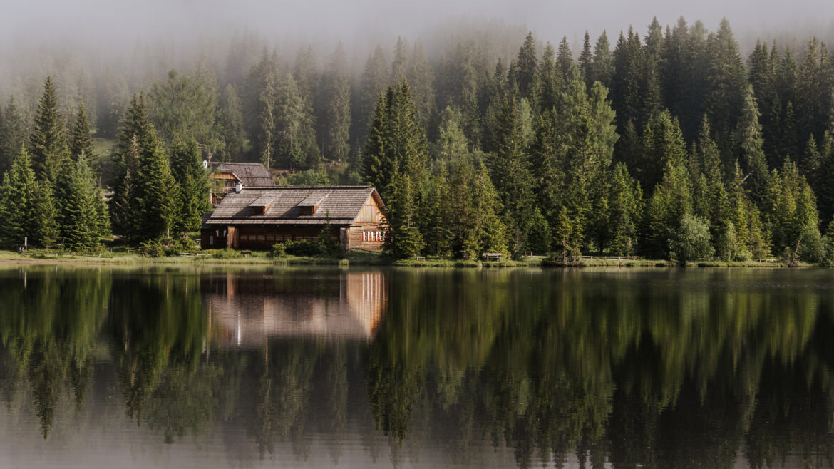 Bergsee in Nebelstimmung, am See spiegelt sich die Hütte
