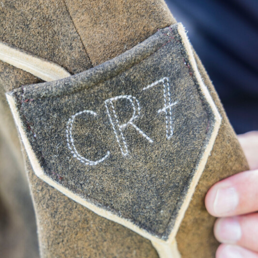 Nahaufnahme einer Jackentasche aus Wildleder mit den mit weißem Garn aufgestickten Initialen CR7.