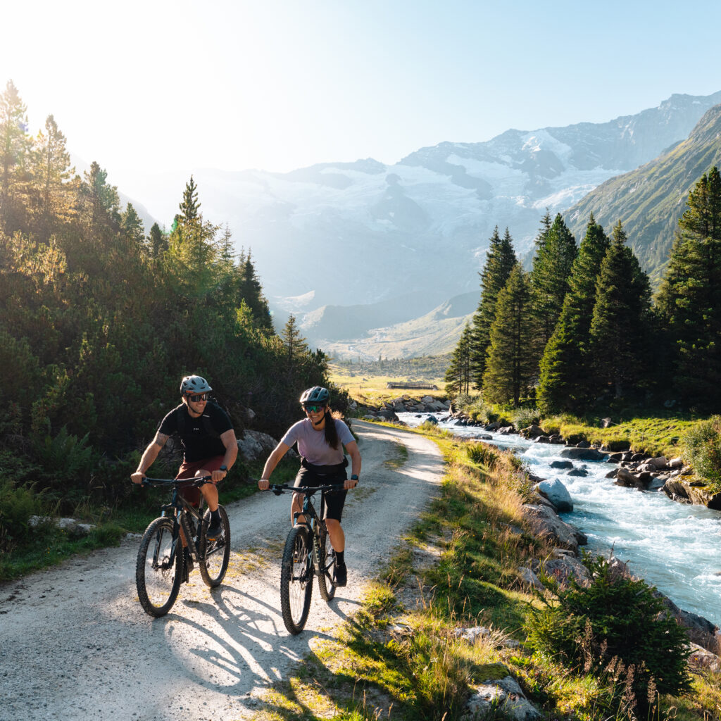 Zwei Biker fahren entlang eines Flusses