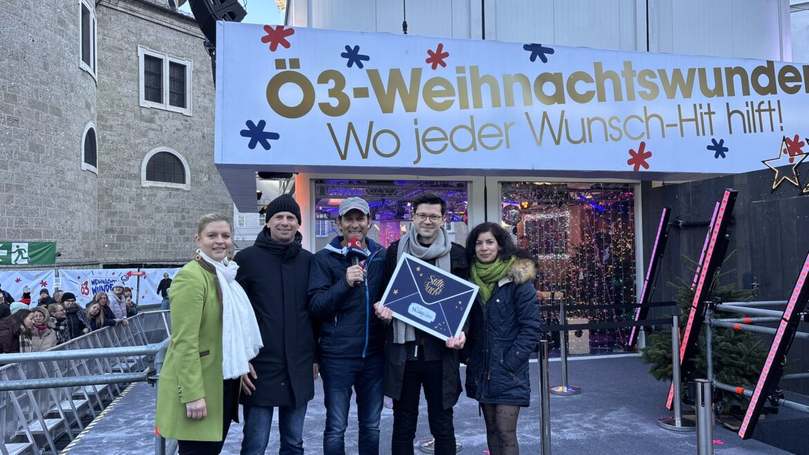 Fünf Personen stehen lächelnd vor einer Veranstaltung mit einem Ö3-Weihnachtswunder-Schild im Hintergrund.